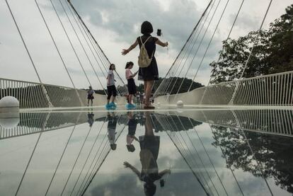 Varios turistas pasean por el puente.