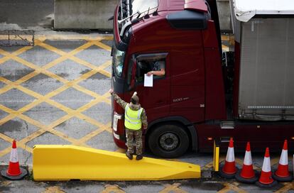 Un soldado revisa los documentos de un conductor en la entrada del Puerto de Dover (Reino Unido). Las autoridades británicas aseguraron que mantendrán los enlaces ferroviarios y marítimos a través del Canal de la Mancha en Navidad para agilizar el cruce de miles de camiones varados tras la aparición de la nueva cepa de coronavirus.