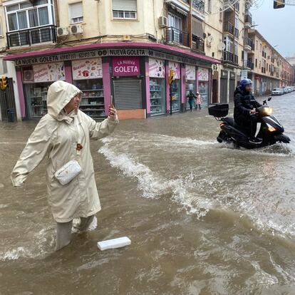 MA06. MÁLAGA, 13/11/2024.- Una mujer hace fotos con el agua hasta las rodillas en Málaga donde las fuertes trombas de agua y granizo que se registran este miércoles han causado inundaciones y la acumulación de grandes balsas en algunas de las principales avenidas de todos los distritos de la ciudad.EFE/María Alonso
