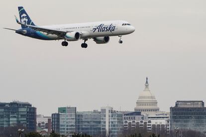 An Alaska Airlines aircraft flies past the U.S. Capitol before landing at Reagan National Airport in Arlington, Virginia, January 24, 2022.