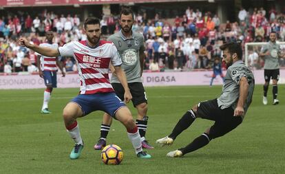 Toral, centrocampista del Granada disputa la pelota a Bruno Gama con Emre Çolak cerca de la acción.