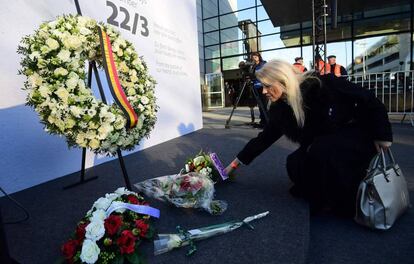 Una mujer deposita una flores durante el homenaje a las víctimas del atentado de Bruselas en el aeropuerto de Zaventem.