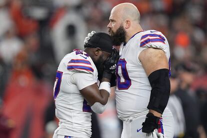 Tre'Davious White y Mitch Morse, compañeros en los Buffalo Bills, lloran y se abrazan al poco de perder el conocimiento Damar Hamlin sobre el césped.