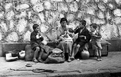 Una mujer da de comer a sus cuatro hijos en un banco de la calle, el 30 de marzo de 1939, en Madrid.