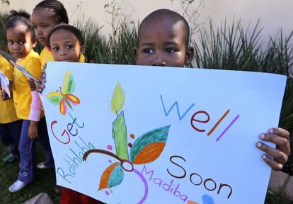 Un ni&ntilde;o sostiene una pancarta para desear una pronta recuperaci&oacute;n al expresidente sudafricano Nelson Mandela.