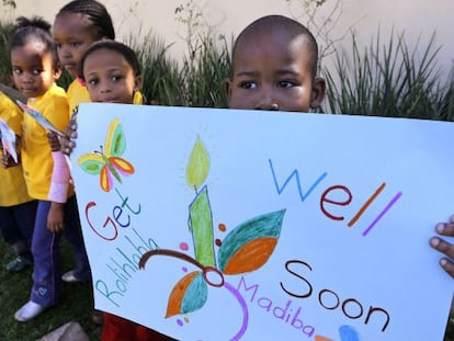 Un niño sostiene una pancarta para desear una pronta recuperación al expresidente sudafricano Nelson Mandela.