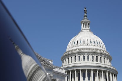 The dome of the U.S. Capitol is reflected in a window on  Capitol Hill in Washington