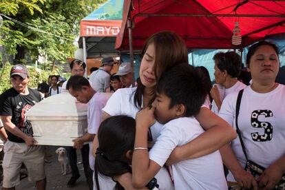 La esposa y los hijos de Alex Hongco lloran mientras sus parientes llevan el ataúd con su cuerpo. Hongco y tres hombres más fueron asesinados cuando la policía irrumpió en una casa de Manila en una redada antidroga en diciembre pasado.
