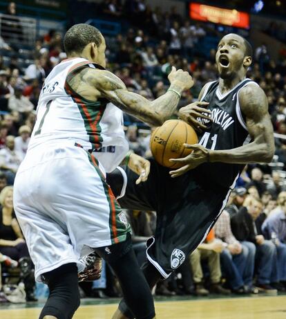 El jugador de los Nets Tyshawn Taylor pierde la bola ante Monta Ellis de los Bucks.