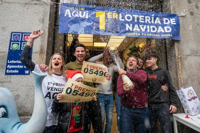 Los empleados de una administración de lotería de la calle del Arenal de Madrid celebran haber vendido el Gordo.