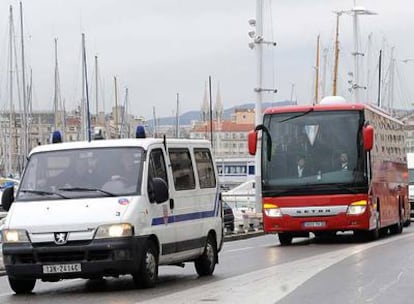 El autocar del Atlético, custodiado por furgones policiales, pasa junto al puerto de Marsella en el trayecto desde el aeropuerto  al hotel.