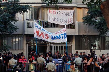 Un grupo de personas se manifiesta con pancartas en contra del expresidente de Chile y candidato presidencial de la coalición Chile Vamos, Sebastián Piñera, mientras acude a votar en Santiago.