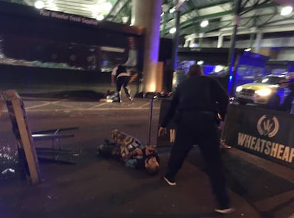 Uno de los sospechosos de los ataques terroristas permanece tumbado en el suelo tras ser reducido por la policía en Borough Market, en Londres.