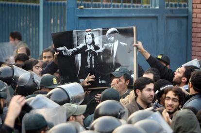 Manifestantes sostienen un póster de la película 'Pulp Fiction' durante la protesta frente a la Embajada británica en Teherán.