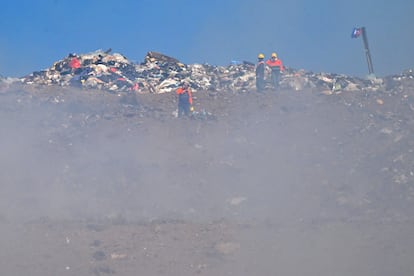 Un equipo de bomberos rodeado por la nube de humo de tóxico generada por el incendio en el Cerro Patacón.