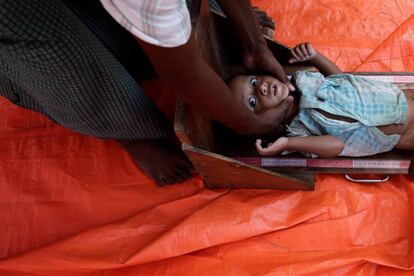 Un sanitario mide a un niño refugiado en un centro médico junto al campamento de Palonkhali, en Cox's Bazar, Bangladés.