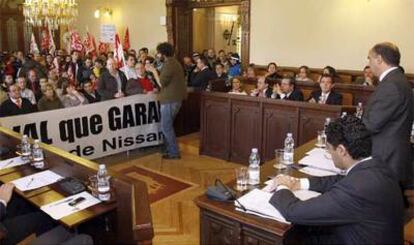 Los empleados de Nissan irrumpen en el pleno del ayuntamiento de Ávila con un pancarta.