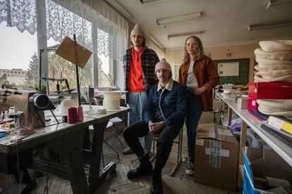 El diseñador Ruslan Baginskiy (en el centro), con dos miembros de su equipo en la escuela de Lviv donde han reorganizado su taller tras huir de Kiev. 