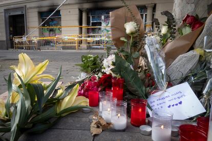 Flores y velas en el recuerdo a la familia fallecida en el incendio del local en el que vivían.