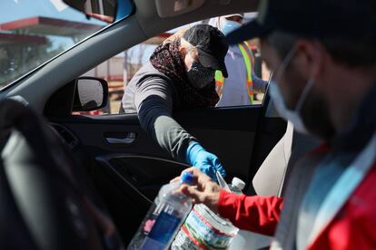 Erin Purdy, una voluntaria, da agua y jugo en un centro de acopio de víveres en Kyle, Texas. La mitad de los 29 millones de habitantes del Estado tiene orden de hervir el agua (para beberla, cocinar o lavarse los dientes) por la posible contaminación derivada de la rotura de tuberías.