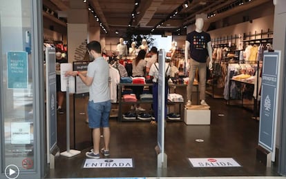 A man uses hand sanitizer before entering a store in Madrid.