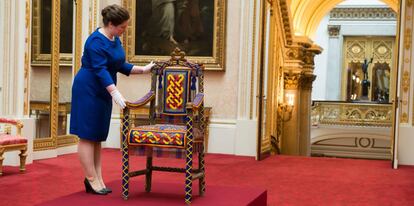 Una encargada de la exhibición de Royal Collection Trust acomoda el trono de Yoruba que fue obsequiado a Isabel II por Nigeria en 1956.
