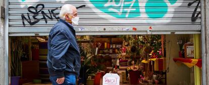 Un hombre pasa ante una floristería cerrada.