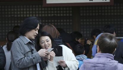 Una pareja lee un mensaje de la fortuna en el templo Asakusa Sensoji de Tokio.