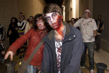 Participantes en la <i>Zombie Walk</i> de Alicante a su paso por un callejón.