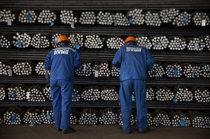 Trabajadores inspeccionan la calidad de las barras de acero en el área de producción de la compañía Acero Group Corporation, en China.