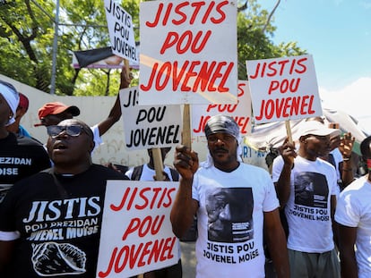 Demonstrators hold signs reading 'Justice for Jovenel' outside a judicial hearing into the assassination of President Jovenel Moise attended by former first lady Martine Moise, in Port-au-Prince, Haiti October 6, 2021.