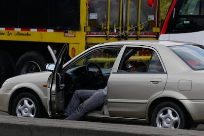 Un hombre duerme en uno de los carros atascados en el bloqueo que completa más de 14 horas.