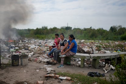 Mujeres se reúnen mientras observan cómo se quema basura cerca de sus casas en Tucumán, Argentina, en 2023. 