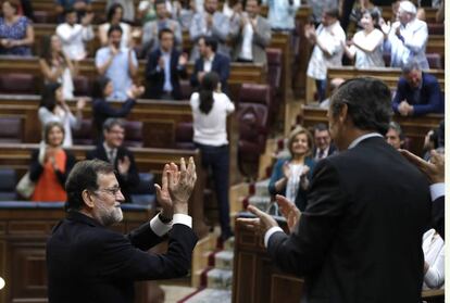 El presidente del Gobierno, Mariano Rajoy, junto al portavoz parlamentario del PP, Rafael Hernando, aplaude con la bancada popular. 