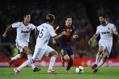 Messi conduce el bal&oacute;n ante rivales del Madrid.
