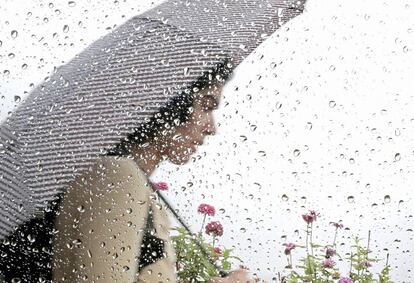 Una estudiante de la Universidad de Wisconsin-Madison se resguarda de la lluvia en el campus de Madison (Wisconsin).