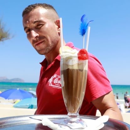 09 August 2022, Spain, Santa Margalida: Abdel, a waiter, serves dessert at the "Chocolate Bar" on the beach in Can Picafort, Mallorca. Photo: Clara Margais/dpa (Photo by Clara Margais/picture alliance via Getty Images)
