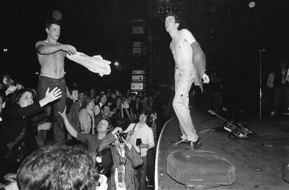 Joe Strummer intercambiándose la camiseta con alguien del público en un concierto de The Clash en 1977.