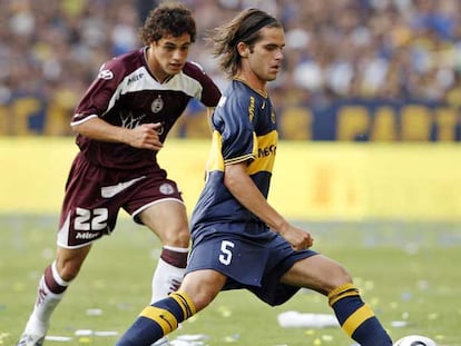 Fernando Gago domina el balón vistiendo la camiseta del Boca ante el acoso de Lautaro Acosta, del Lanús.