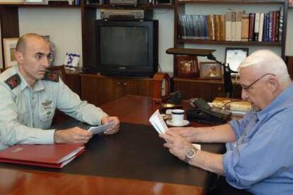 El primer ministro israelí, Ariel Sharon, lee un documento en su despacho después de salir del hospital.