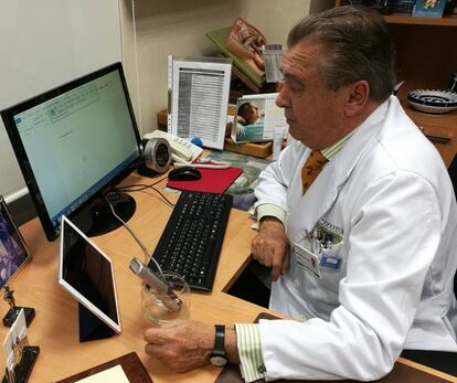 El doctor Enrique P&eacute;rez-Castro dicta a su micr&oacute;fono en la consulta.