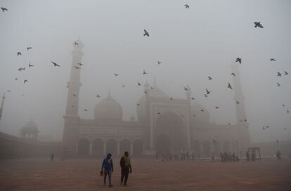 Esta irrespirable atmósfera es producto de una conjunción de superficies agrícolas quemadas y de emisiones urbanas. En la foto, varios visitantes caminan frente a la mezquita Jama Masjid en el casco antiguo de Nueva Delhi.