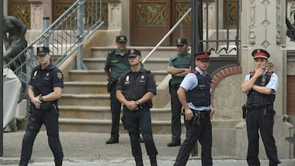 Miembros de la Guardia Civil, de la Policía Nacional y de los Mossos d'esquadra en la puerta de la Delegación del Gobierno en Barcelona.
