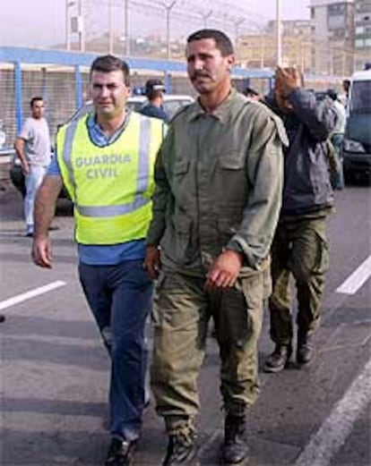 Efectivos de la Guardia Civil acompañan en la frontera de Ceuta a los soldados marroquies apresados en la isla Peregil.