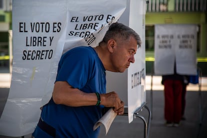 Un hombre sale de una casilla con su voto en mano, en un colegio electoral en el municipio de Santiago Tianguistenco, en el Estado de México.
