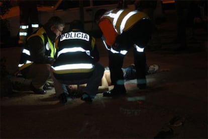 Los agentes de policía examinan el cuerpo del joven dominicano apuñalado.