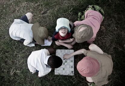 Un grupo de niños juegan a las damas en la Mwisenge Primary School.