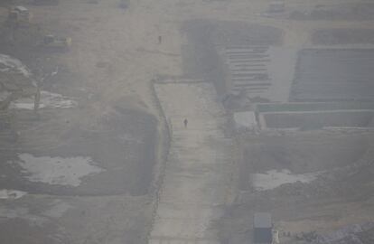 Un obrero camina por un solar en el barrio financiero de Pekín.