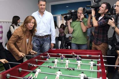 La presidenta del PPC, Alicia Sánchez Camacho, juega al futbolín ante Albiol este jueves en una ludoteca de Barcelona.