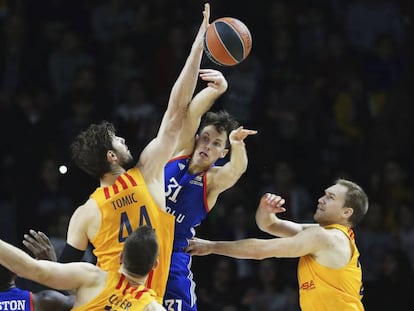 Heurtel pasa un bal&oacute;n entre Tomic y Oleson.